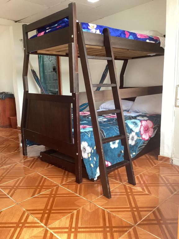 Manizales premium stay في مانيزاليس: سريرين بطابقين في غرفة مع أرضية خشبية