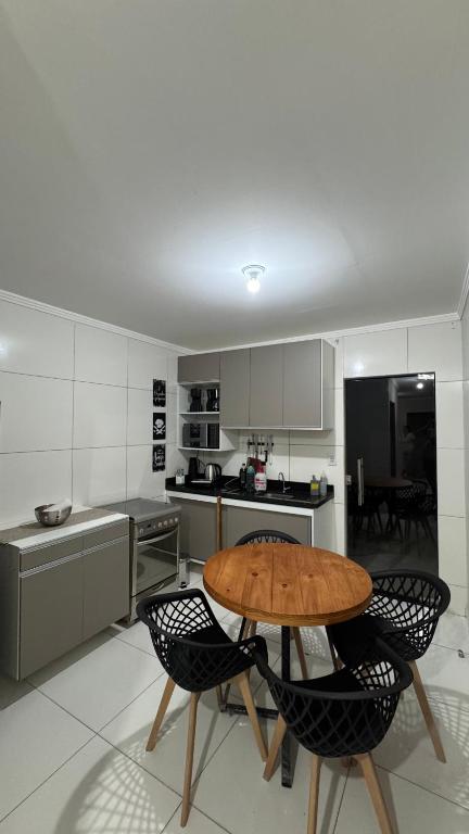 a kitchen with a wooden table and two chairs at Casa com 2 Quartos Climatizados e Garagem in Juazeiro
