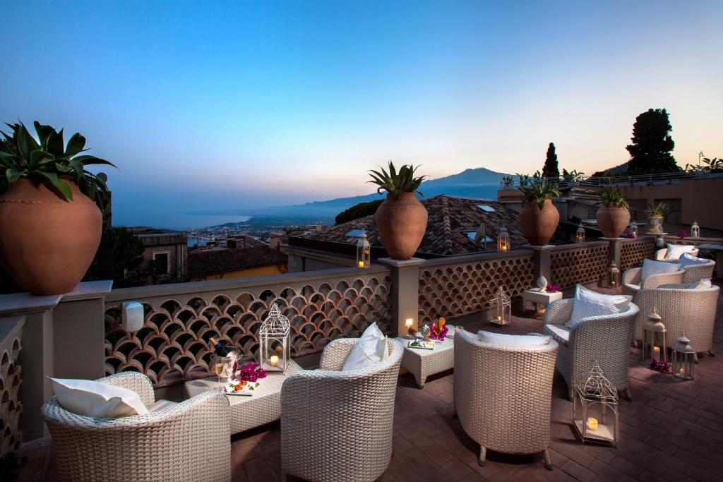 a restaurant with chairs and tables on a balcony at Hotel Villa Taormina in Taormina