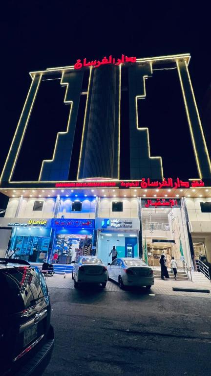two cars parked in front of a gas station at night at شقق دار الفرسان المخدومة اقتصادي in Quai