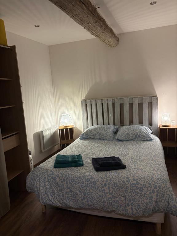 a bedroom with a bed with two bags on it at À mi-chemin in Claira