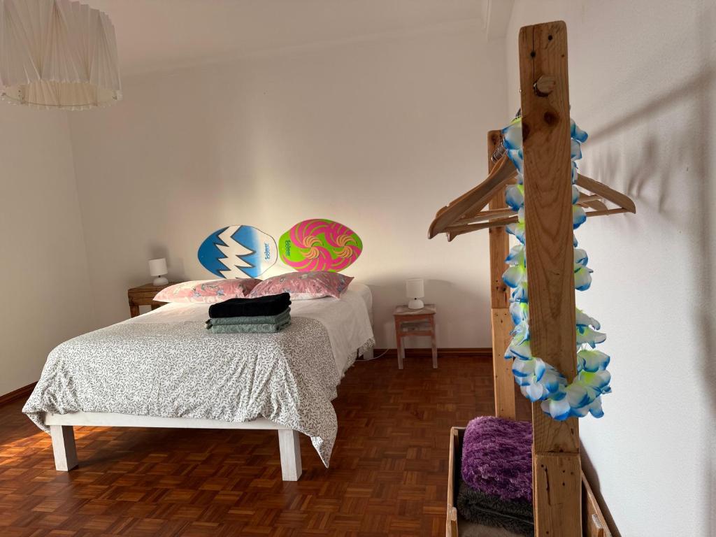 a bedroom with a bed and a wooden cross at Ericeira - Casa Tia Alice in Ericeira