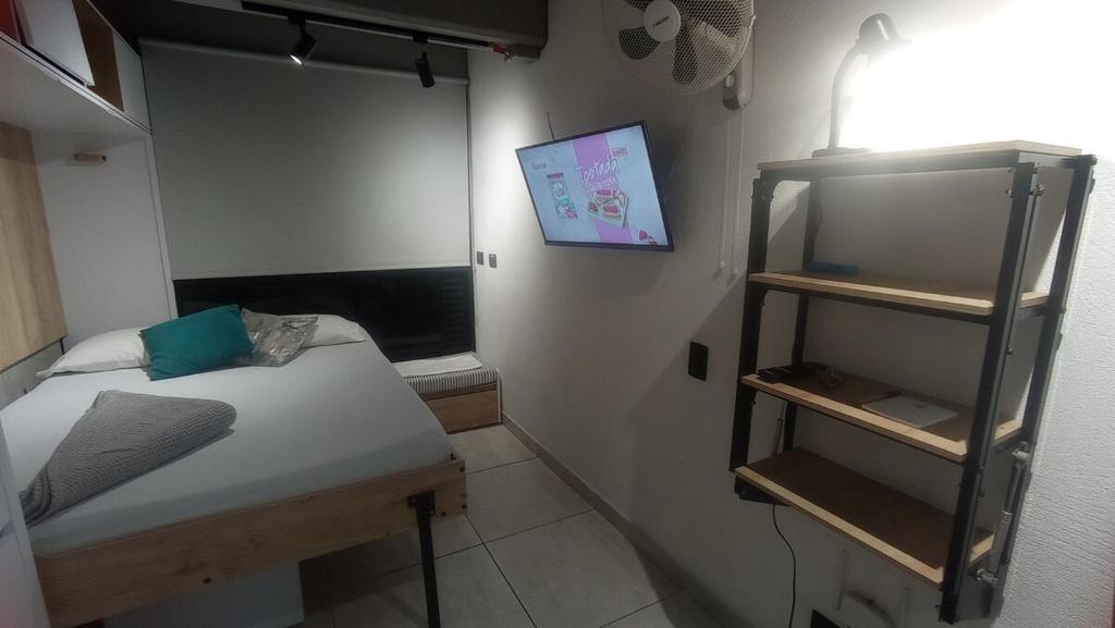 a small room with a bed and a shelf at BOHÍO del Pescador Barquero - Diverso y con Alma in Medellín