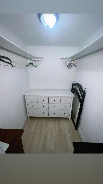 a bedroom with a white dresser and a light at Drip Star Life Hostel Miami in Parkway Regional Medical Center Heliport