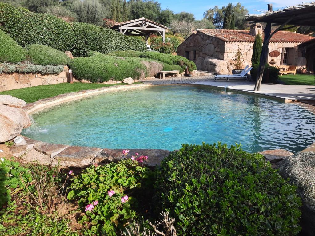 Una gran piscina en un patio con flores. en Casa di Sognu, en Porto Vecchio