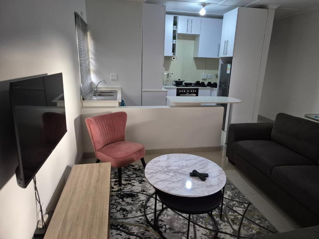 a living room with a couch and a table at Charming Cottage for Getaways in Empangeni