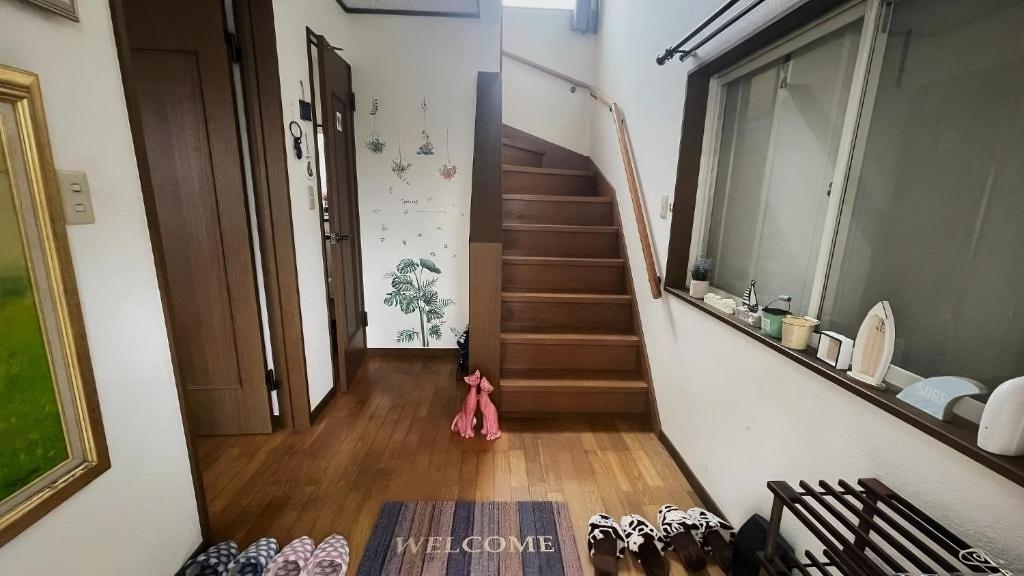 a hallway with stairs and shoes on the floor at ELM On The Beach in Kitaibaraki