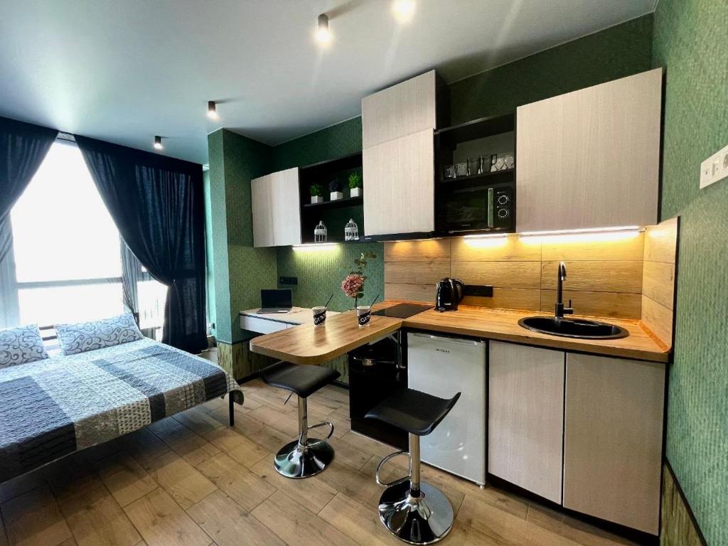 une petite chambre avec un lit et une cuisine dans l'établissement sixkeys- studioLebedinyy, à Kiev