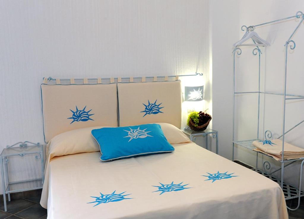 a bedroom with a bed with blue pillows on it at Alghero Sunrise in Alghero