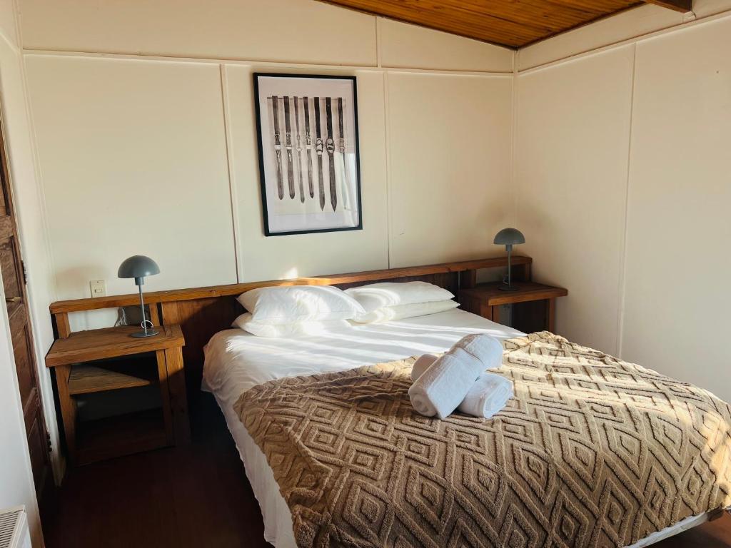 a bedroom with a bed with towels on it at Hostal Cabaña Farellones in Santiago