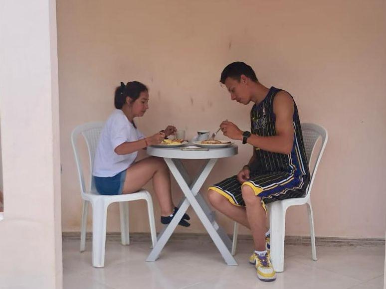 a man and a woman sitting at a table with a baby at Habitacion Pauvemar en Coveñas in Coveñas