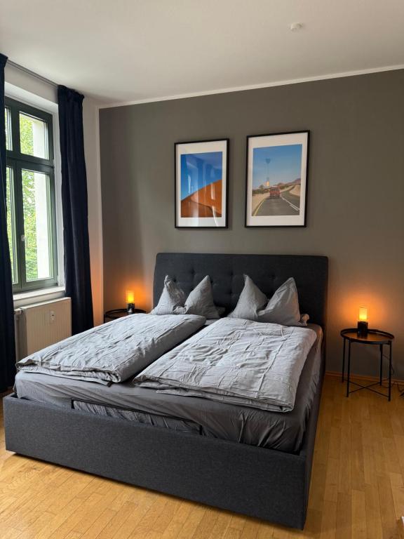 a bedroom with a bed with three pictures on the wall at Wohnung in Leipzig in Leipzig