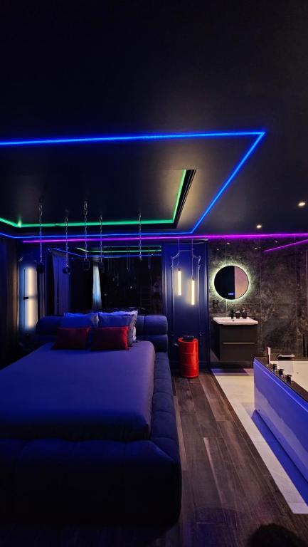 een woonkamer met een bank en een blauw licht bij Love room - Xtase By luxuria Cannes in Cannes