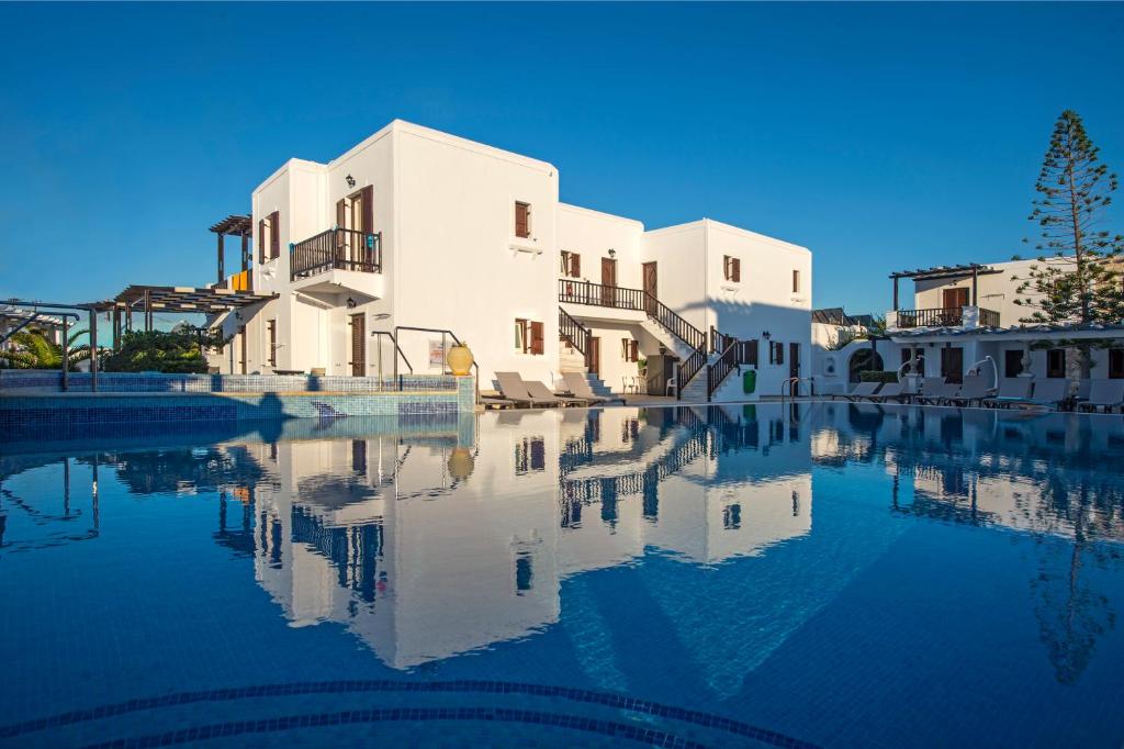 a building with its reflection in a pool of water at Contaratos Beach Hotel in Naousa