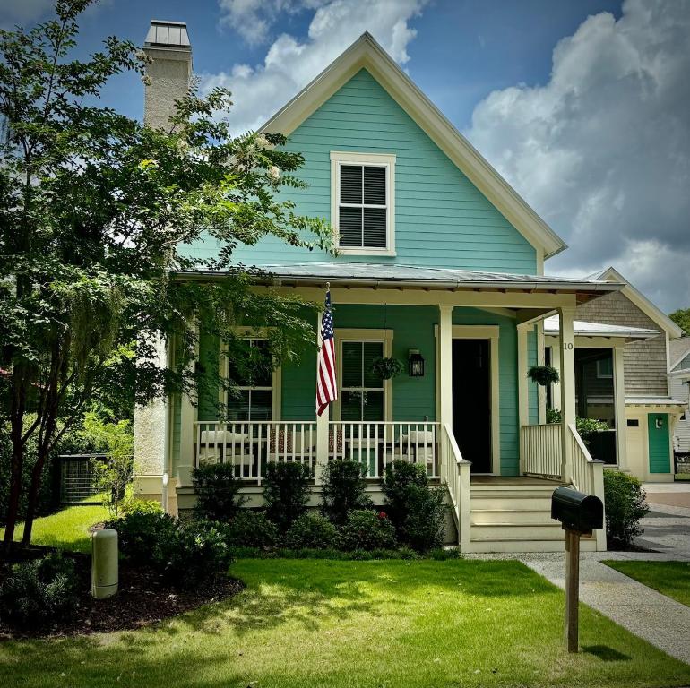 ブラフトンにあるWharf Street Coastal Escape - 3BR Old Town Luxuryの正面玄関の旗付き青い家