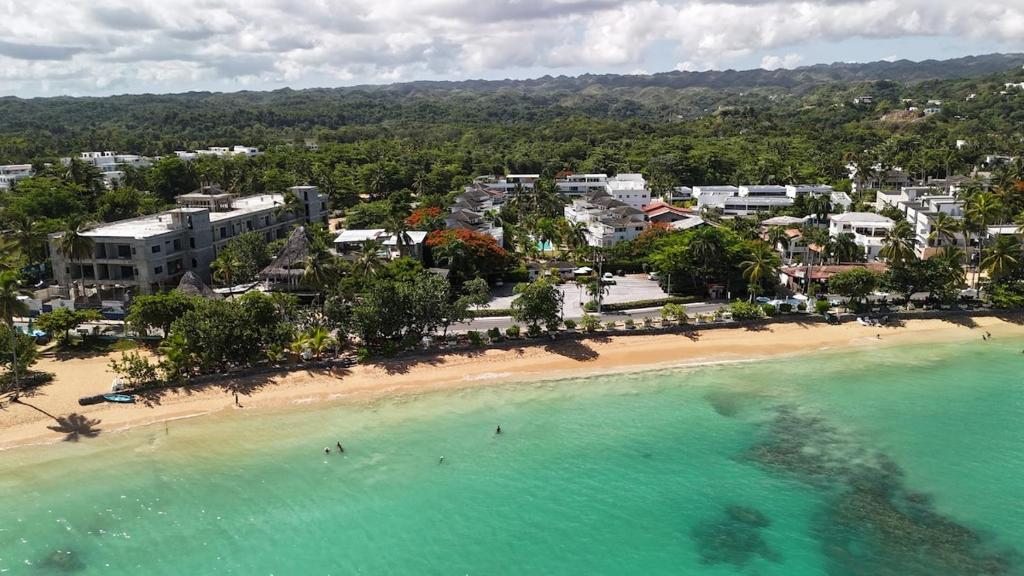 an aerial view of a beach with people in the water at La Fenice 3 Bedroom Beachfront Apartment in Las Terrenas