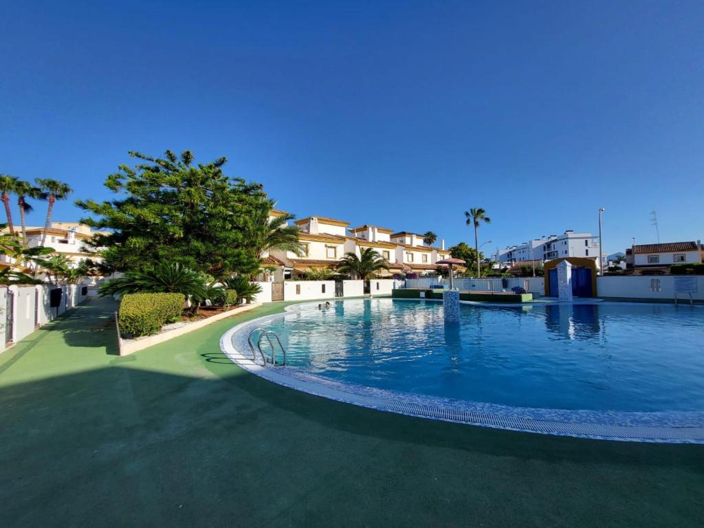 a large swimming pool in the middle of a resort at MET Oliva Nova Playa chalet grande con jardín MET a 5 minutos y a 3 de la playa in Oliva