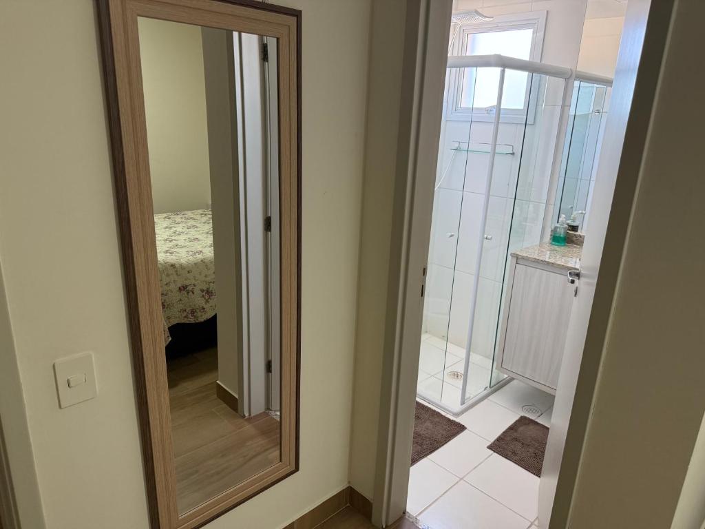 a mirror in a room with a bathroom at Lazer de resort e vista marcante in Guarujá