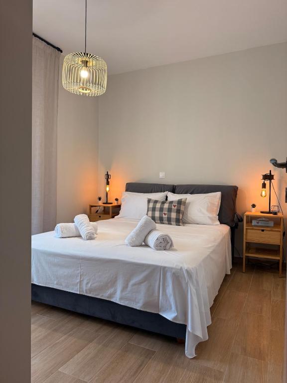 a bedroom with a large white bed with a chandelier at Kyveli Apartment in Karistos