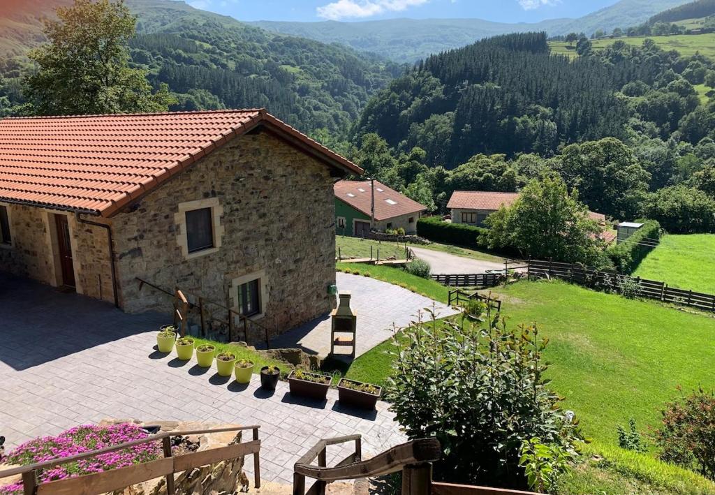 une maison en pierre avec vue sur un jardin dans l'établissement CASA DE LA LASTRA Luena, à San Miguel de Luena