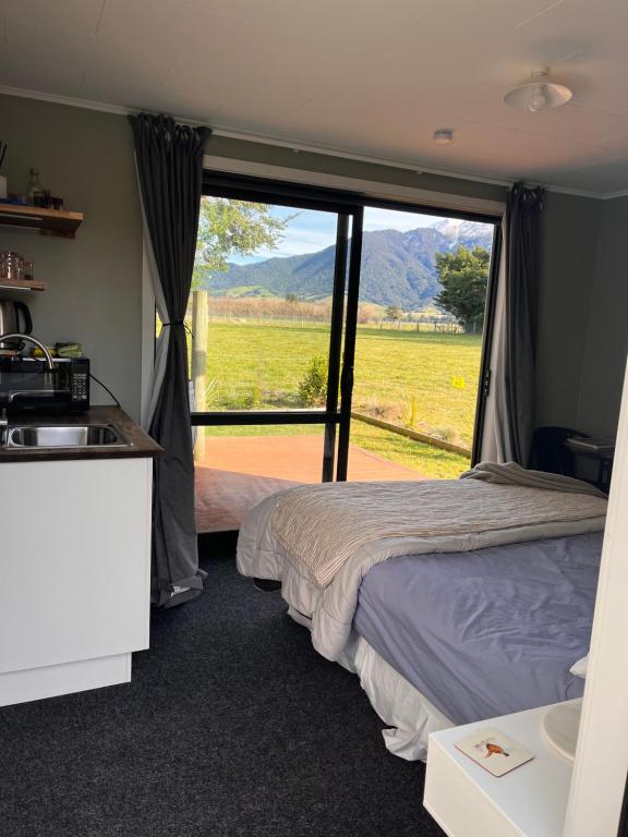 a bedroom with a bed and a sink and a window at Adorable studio cottage with mountain views in Staveley