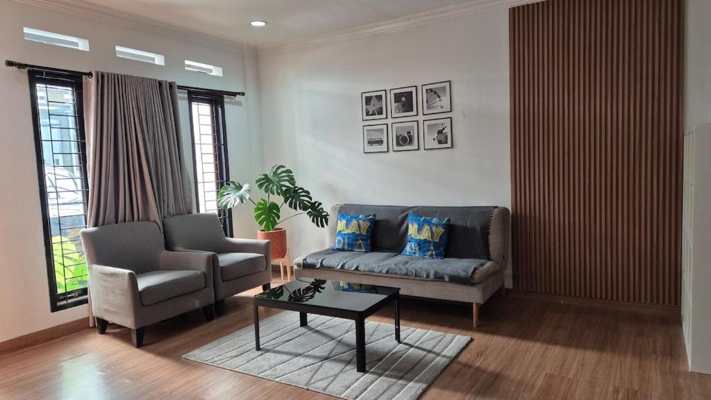uma sala de estar com um sofá e uma mesa em Dago Family Stay em Bandung