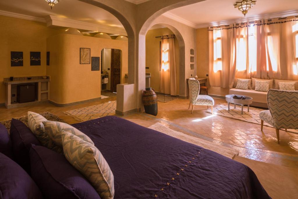 une chambre avec un lit et un salon dans l'établissement Riad Serai Merzouga, à Merzouga