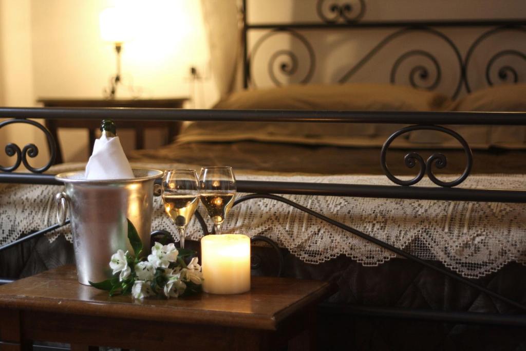Una cama con una vela y dos vasos sobre una mesa en Residenza Millennium, en Florencia