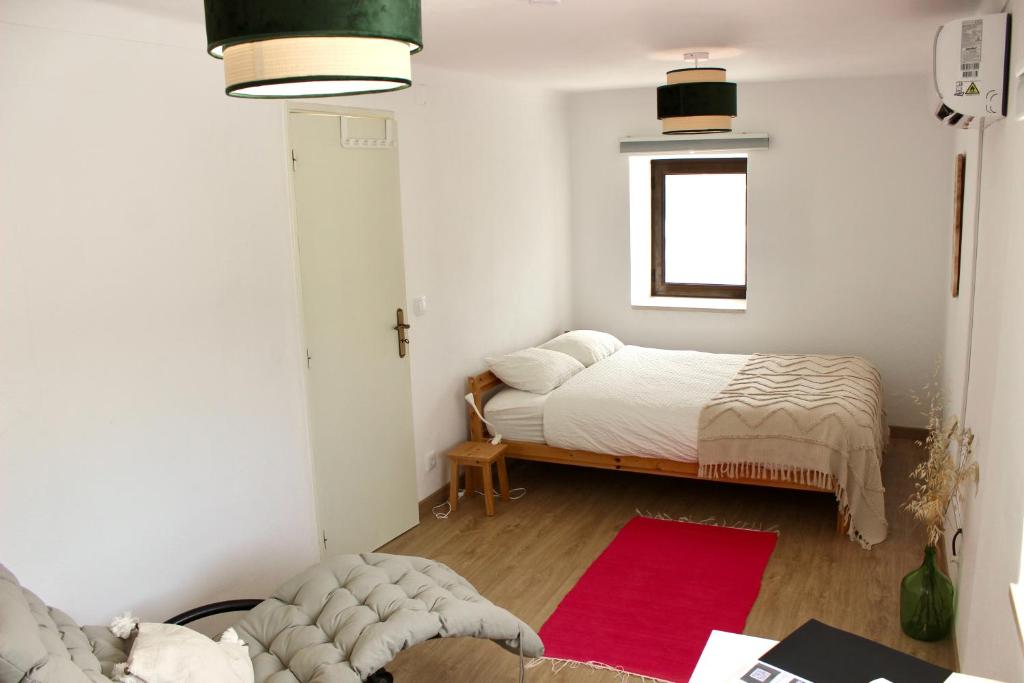 a bedroom with a bed and a red rug at Vivenda Montanha Apartment in Alcaria