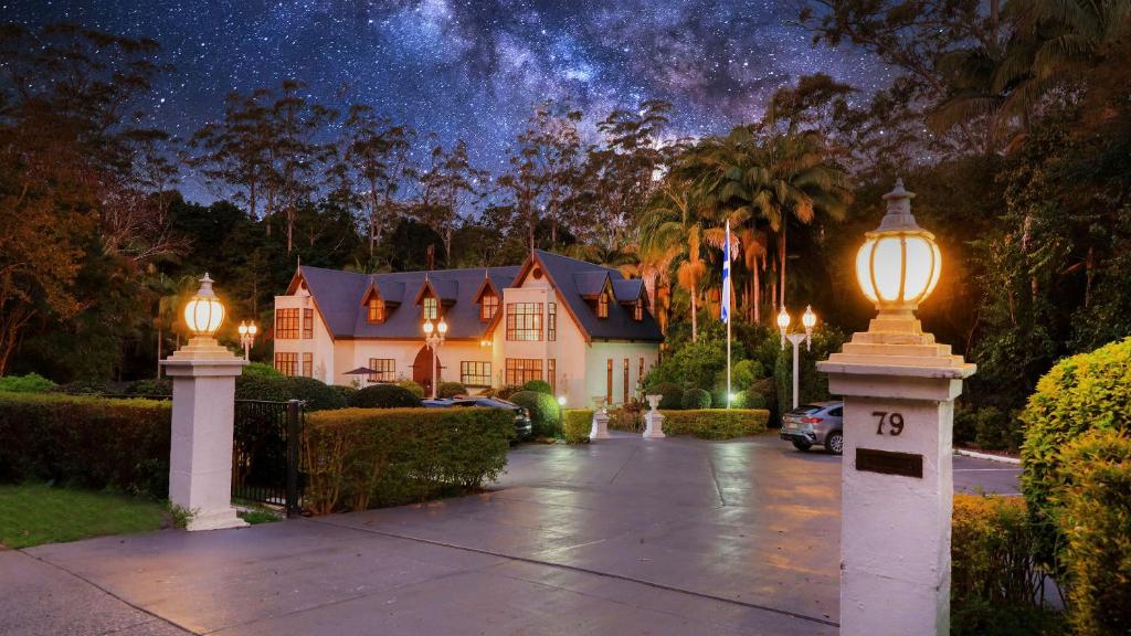 a house with a street light on a driveway at night at Mt Tamborine Stonehaven Manor in Mount Tamborine