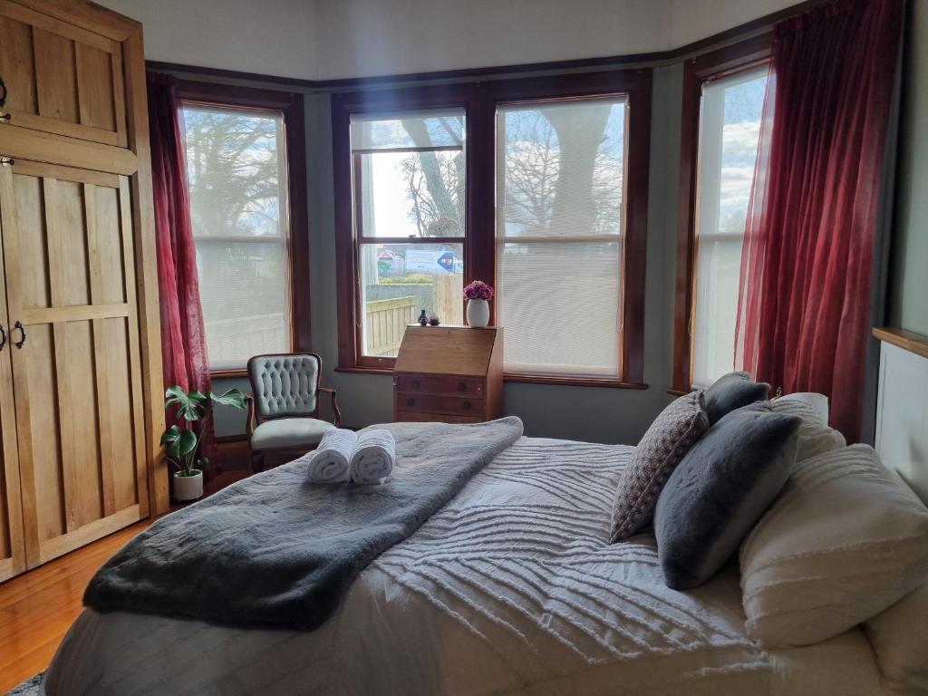 a bedroom with a large bed with towels on it at Villa Charm on Claudelands in Hamilton