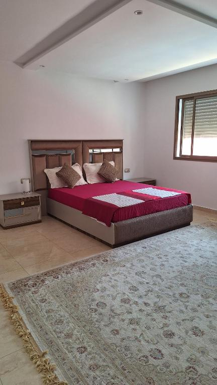 Un dormitorio grande con una cama grande y una alfombra. en Chambres au sein d'une villa, en Rabat