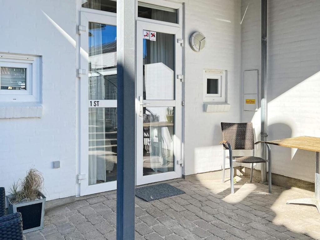 a door to a building with a table and a chair at Central Oasis in Lokken - By Traum Ferienwohnungen in Løkken