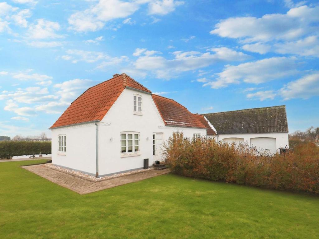 a white house with an orange roof at 8 person holiday home in Bogense-By Traum in Bogense