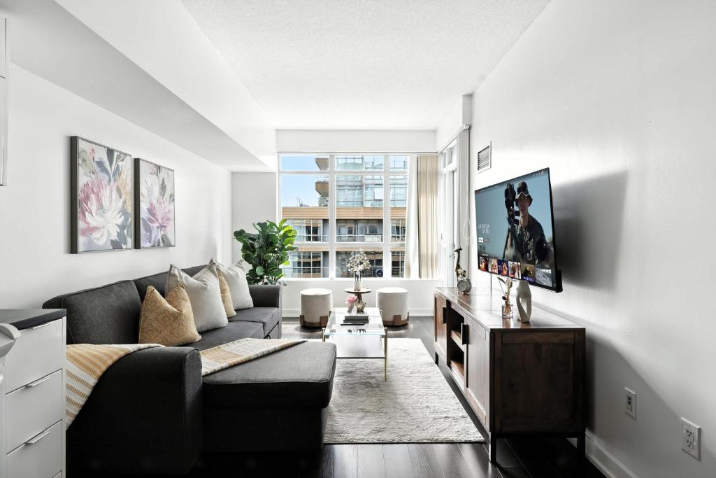 a living room with a couch and a tv at Modern Lakefront Escape Walk to Waterfront in Toronto