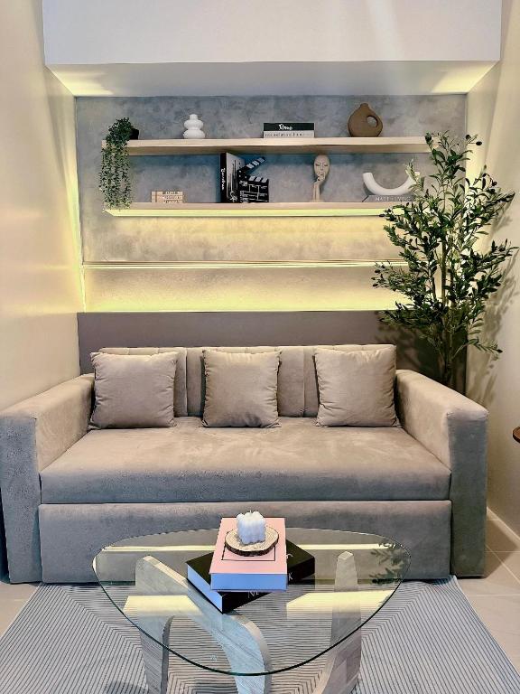 a living room with a couch and a glass table at Kasara Urban Residences in Pasig City - Solmera Cove in Manila