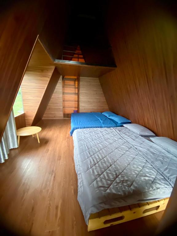a bedroom with a bed and a wooden floor at Biển Hồ Garden Glamping in Bien Ho