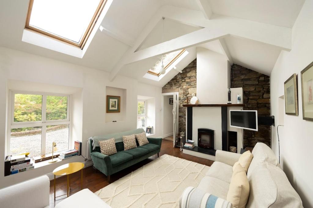 a living room with a couch and a fireplace at The Cottage at Lennaght in Inistioge