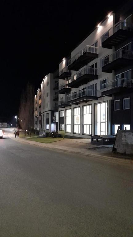 a building at night with a parking lot in front at Departamento Rincon Pinamar in Pinamar
