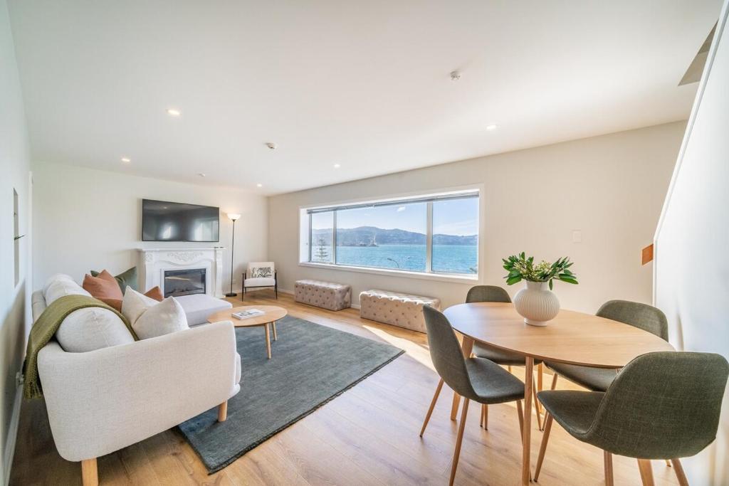 a living room with a couch and a table at Luxury Beachfront Apartment in Wellington