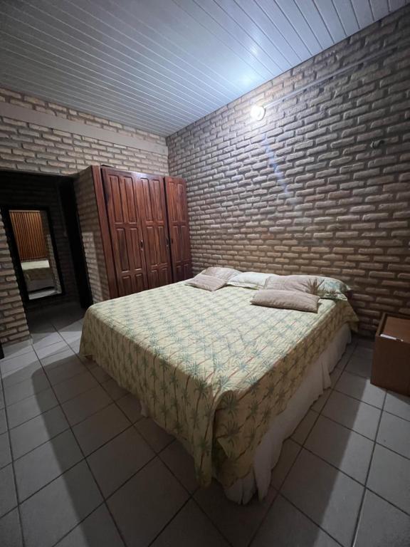 sypialnia z łóżkiem i ścianą z cegły w obiekcie Casa de Praia em Flecheiras Ana w mieście Trairi