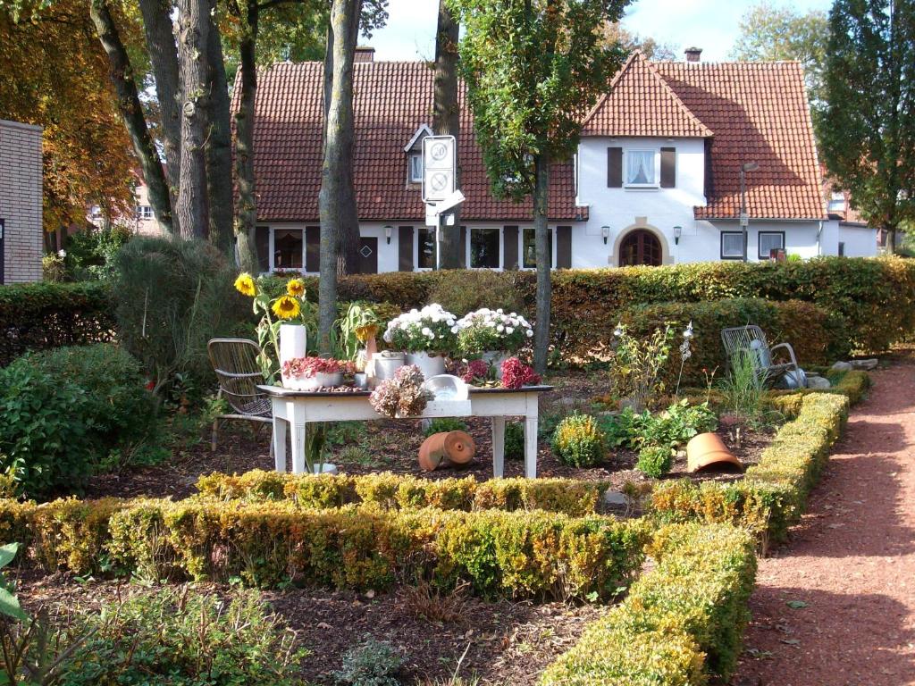 um jardim em frente a uma casa com flores sobre uma mesa em Gästezimmer Lammersmann em Reken