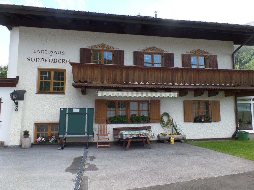 a building with a balcony and a table in front of it at Landhaus Sonnenberg in Sankt Anton am Arlberg