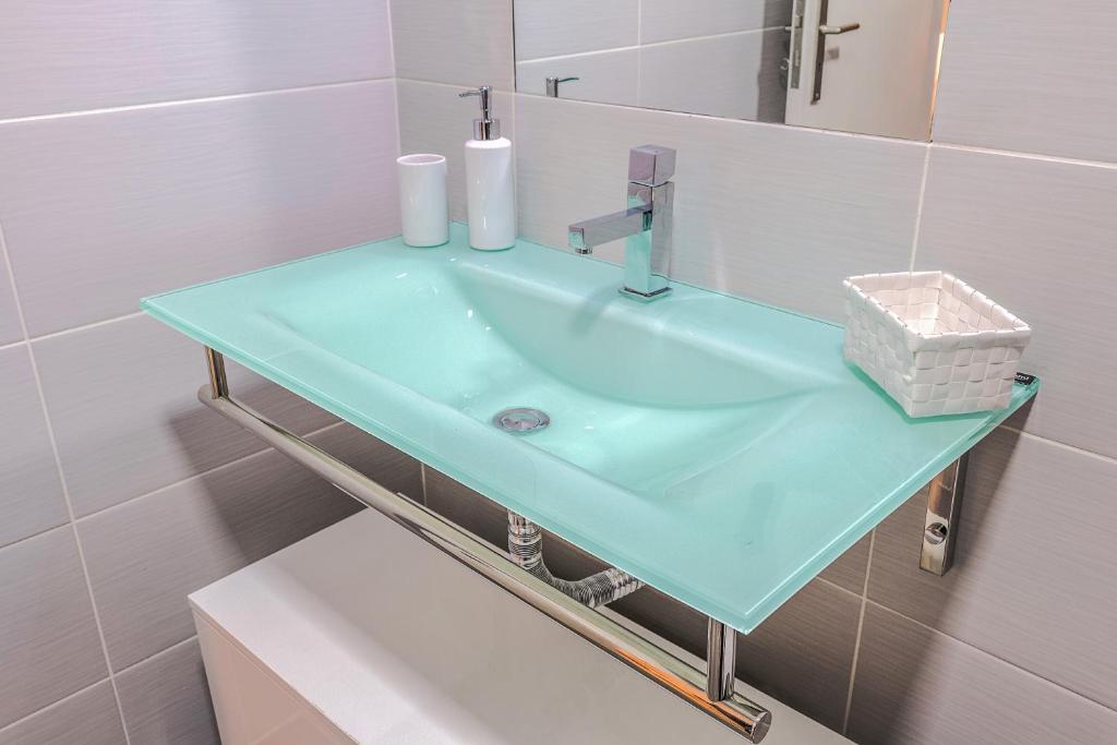 y baño con lavabo azul y espejo. en Bracara Guest House "Arcada", en Braga