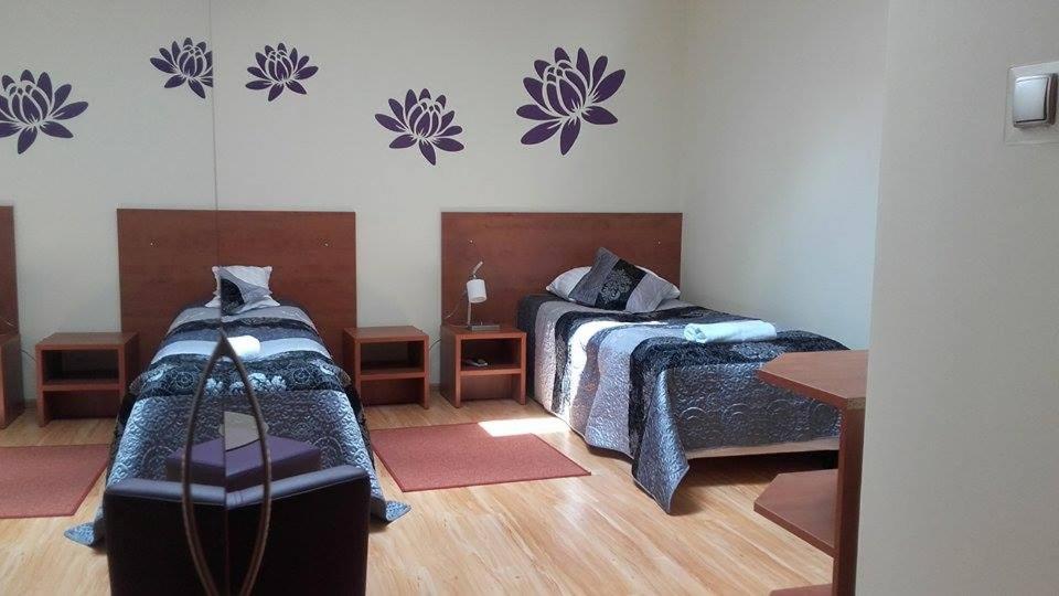 1 dormitorio con 2 camas y espejo en la pared en Hotel Restauracja Księżycowa, en Siedlce