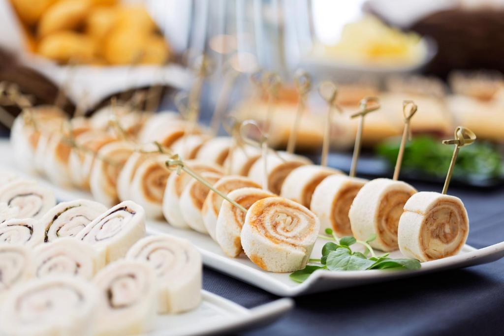 a row of pastries on plates on a table at Troia Design Hotel in Troia