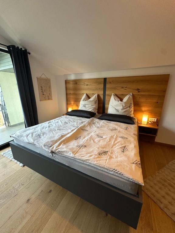 a bedroom with a large bed with a wooden headboard at Gemütlich wohnen mit Weinblick in Horrweiler