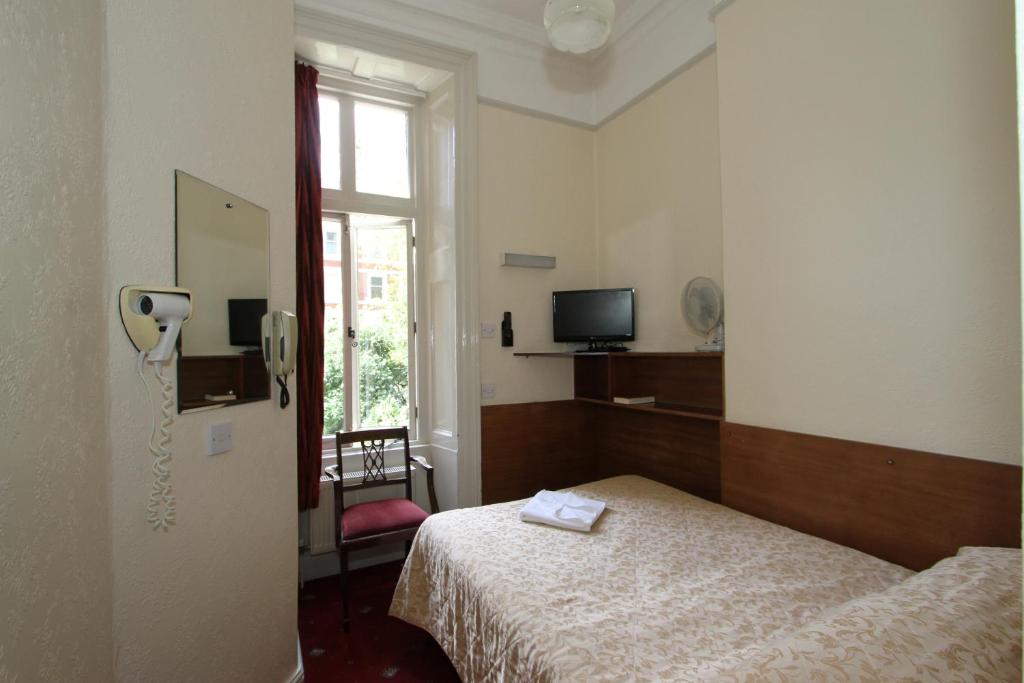 a room with a bed and a phone in it at Ridgemount Hotel in London