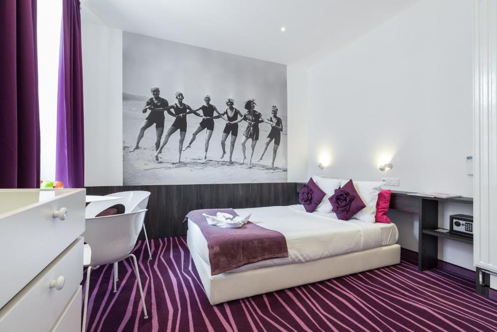 a hotel room with a bed and a painting of women dancing at Nice Appart in Nice