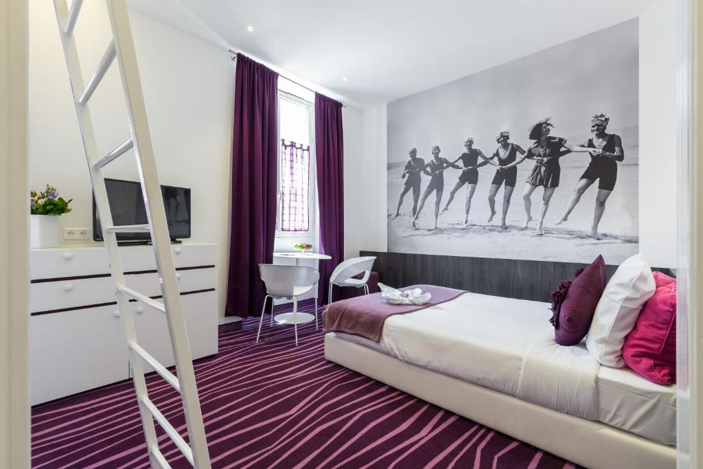 a bedroom with a bed with a poster of women dancing at Nice Appart in Nice